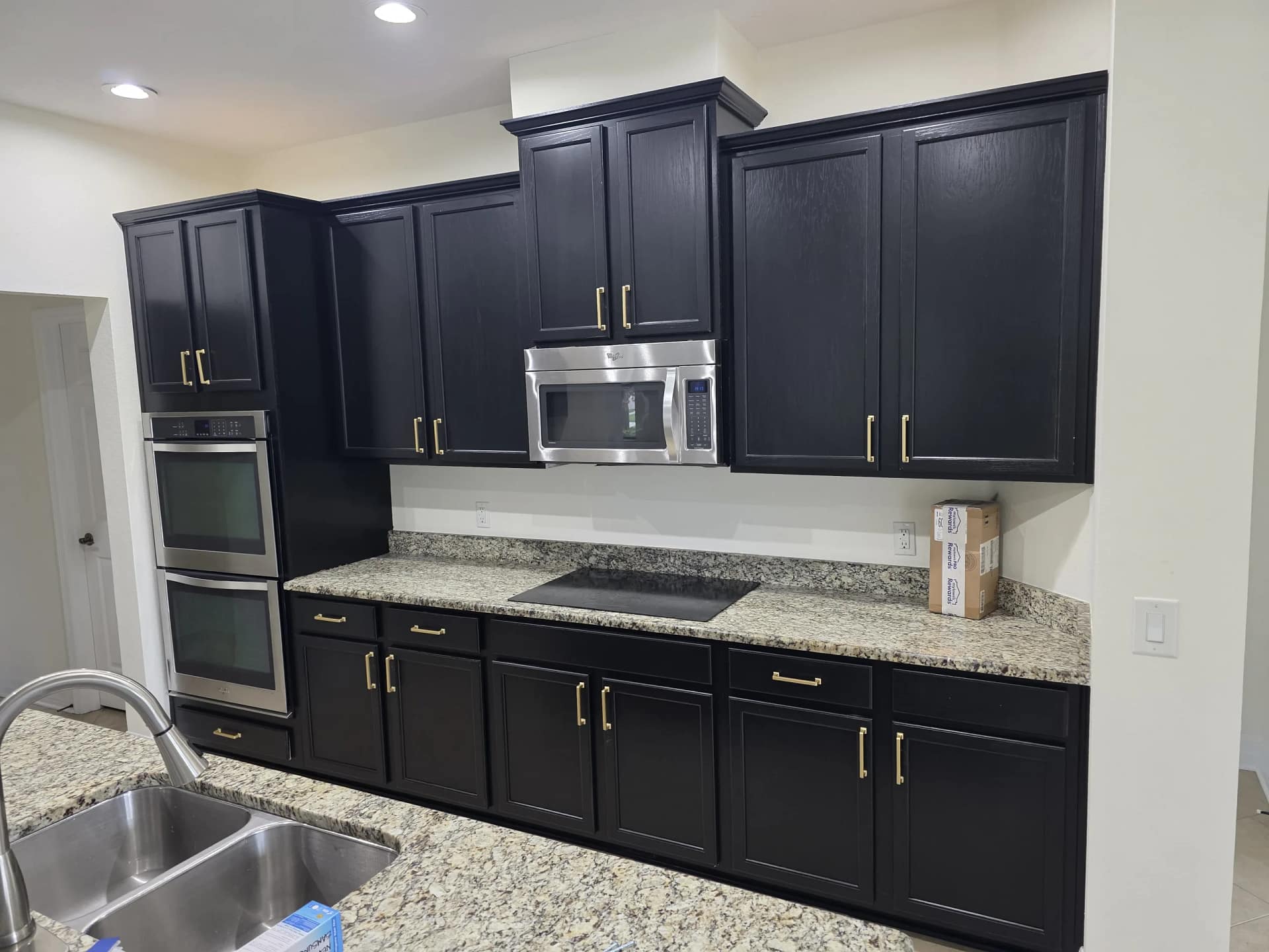 Dark kitchen cabinets with a smooth, consistent painted finish after completion