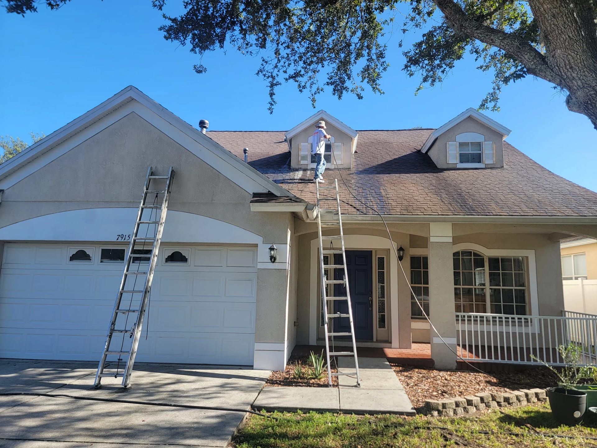 Front exterior of a home being painted during a scheduled work period